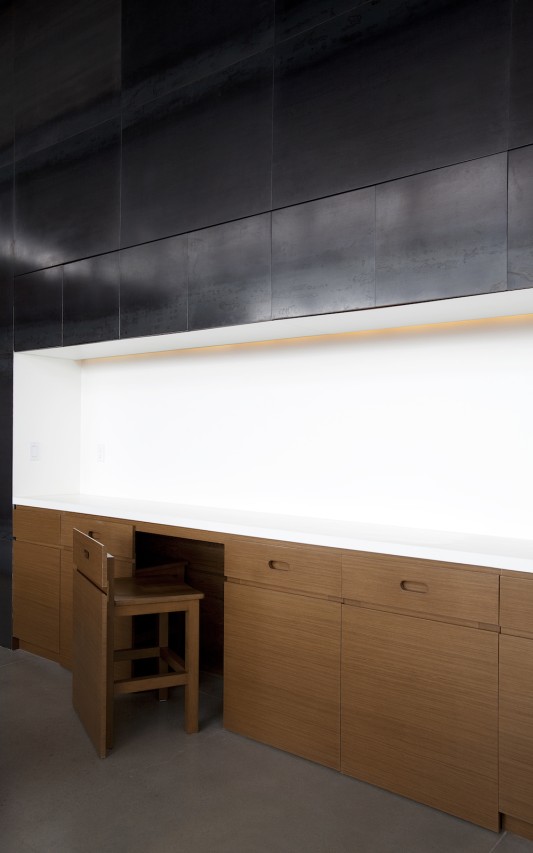 The storage wall contains a set of extra seats for visitors. The additional seats go unnoticed, maintaining the aesthetics of the space